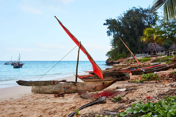 Boat with red sail at the beach ロイヤリティフリーのストック写真