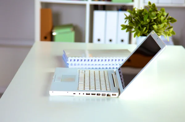 Zavřít pohled na pracovní stůl interiéru s přenosným počítačem, šálek kávy a bílé záclony na slunečný den — Stock fotografie