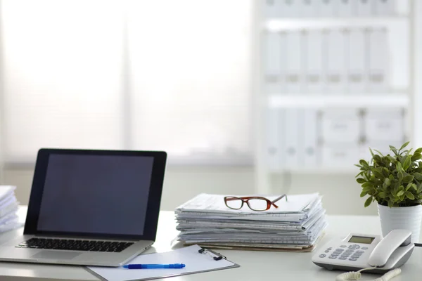 Laptop mit Stapel von Ordnern auf weißem Hintergrund — Stockfoto