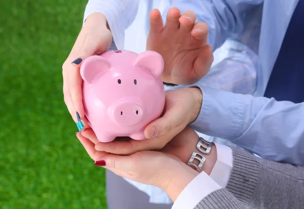 Affärsman holding piggy box, står i office — Stockfoto