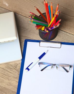 kalem ile ahşap masa üstünde boş defter