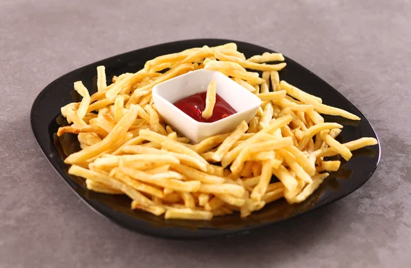 Batatas fritas no prato de pé a mesa de madeira — Fotografia de Stock