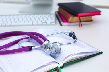 Açık bir kitap bir masanın üzerinde yatan stetoskop