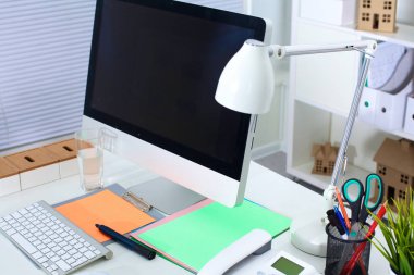 Bilgisayar ve evrak ile tasarımcı çalışma masası