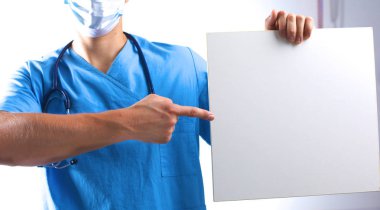 cerrah maskeli bir afişini tutar