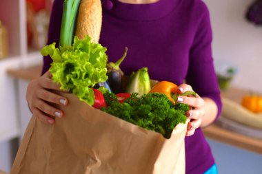 meyve ve sebze dolu alışveriş kese kağıdı tutan pozitif sağlıklı mutlu kadın