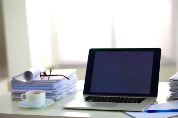 Laptop met stack van mappen op tafel witte achtergrond — Stockfoto