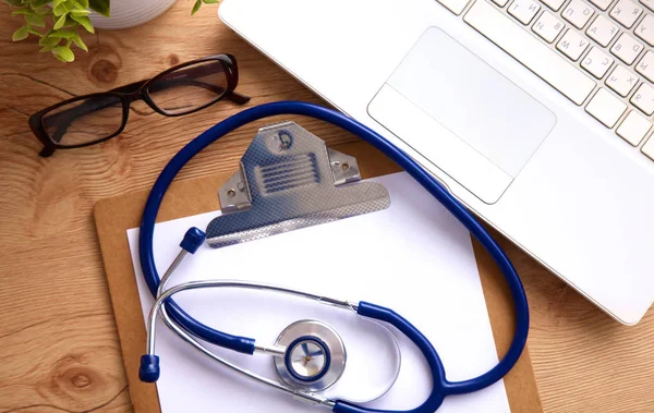 Medical stethoscope near  laptop on  wooden table,  white — Stock Photo, Image