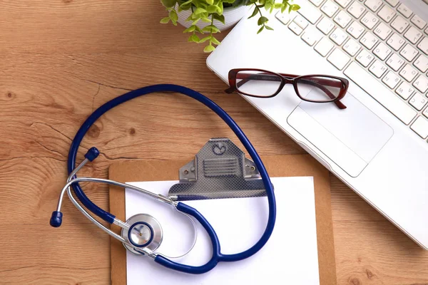 Medical stethoscope near  laptop on  wooden table,  white — Stock Photo, Image