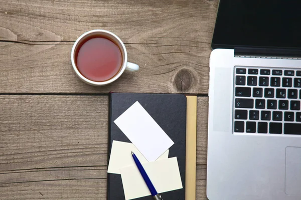 A toll, a laptop és a tea cup-a fából készült irodai asztal üres névjegykártyák — Stock Fotó