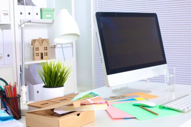 Bir bilgisayar ve evrak ile tasarımcı çalışma masası