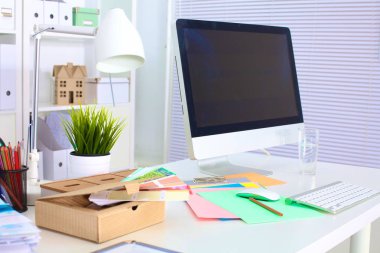 Bir bilgisayar ve evrak ile tasarımcı çalışma masası