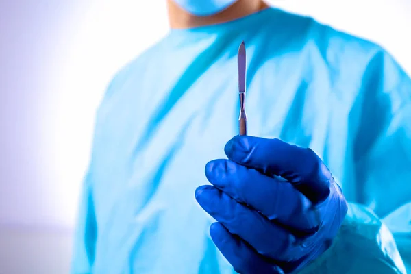 Χειρουργός άνθρωπος κατέχει ένα νυστέρι σε μια αίθουσα εκμετάλλευσης — Φωτογραφία Αρχείου