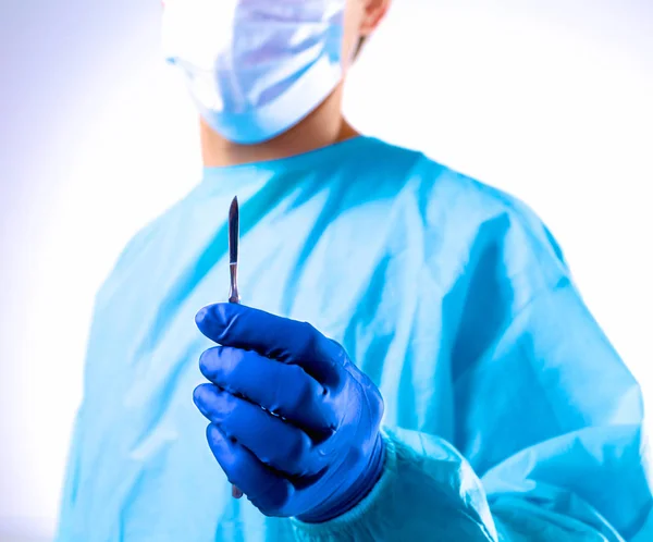 Man kirurg innehar en skalpell i ett operationsrum — Stockfoto