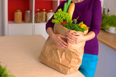 meyve ve sebze dolu alışveriş kese kağıdı tutan pozitif sağlıklı mutlu kadın