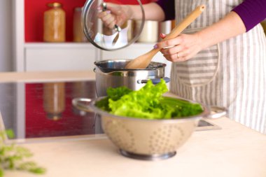 Genç kadın mutfakta yemek pişiriyor. Sağlıklı Yemek