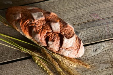 rustik kaşarlı ekmek ve buğday kulaklara koyu ahşap bir masa