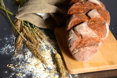 rustik kaşarlı ekmek ve buğday kulaklara koyu ahşap bir masa