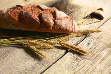 rustik kaşarlı ekmek ve buğday kulaklara koyu ahşap bir masa