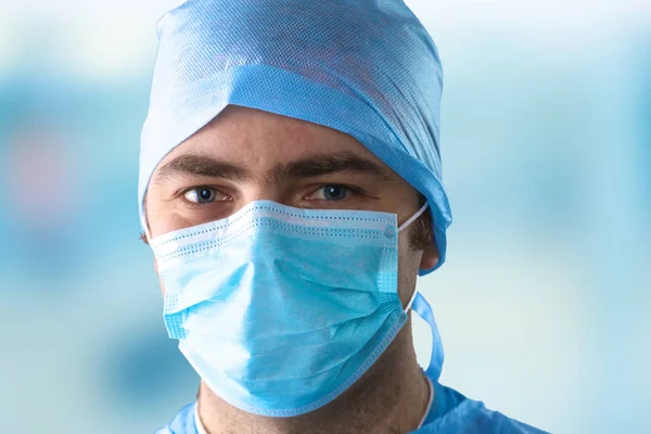 Hombre cirujano sostiene un bisturí en un quirófano — Foto de Stock