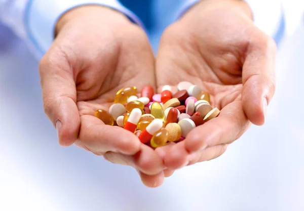 Fiatal orvos tartja a beteg kezét tabletták — Stock Fotó