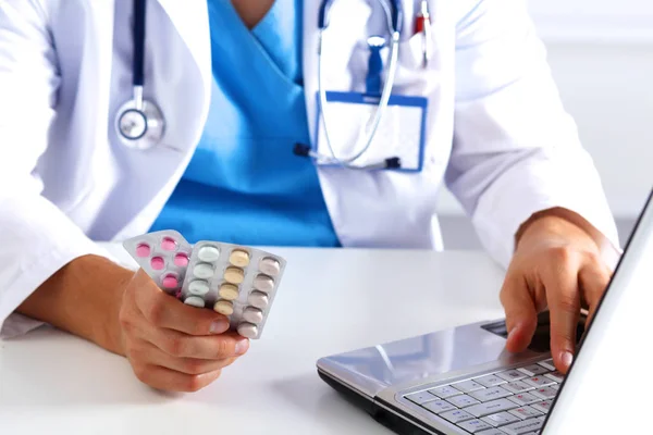 Junge Ärztin hält Patienten die Hand mit Tabletten — Stockfoto