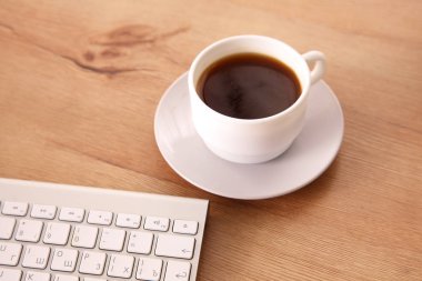 Masaüstü bilgisayar ve bir fincan kahve