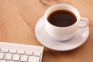 Masaüstü bilgisayar ve bir fincan kahve