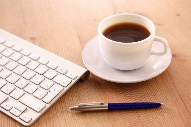 Masaüstü bilgisayar ve bir fincan kahve