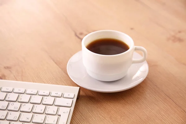 На настольном компьютере и за чашкой кофе — стоковое фото