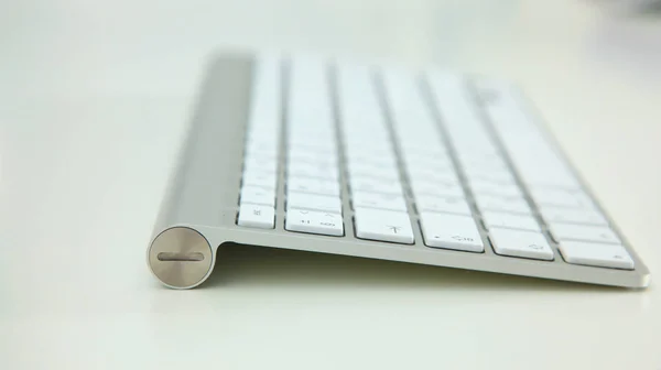 スタイリッシュなアルミのキーボードにある白いテーブルの上 — ストック写真