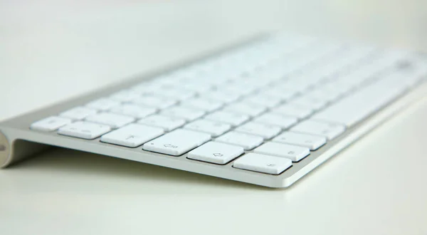 スタイリッシュなアルミのキーボードにある白いテーブルの上 — ストック写真