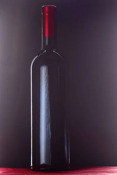 Бутылка вина и бокал на столе — стоковое фото