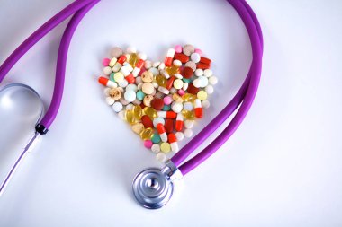 Stetoskop ve beyaz arka planda izole edilmiş bazı haplar.