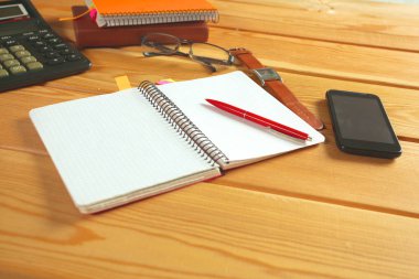 defter, smartphone, gözlükleri ve kalem ile ahşap bir masa yüzeyine