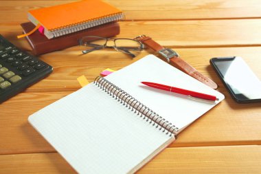 defter, smartphone, gözlükleri ve kalem ile ahşap bir masa yüzeyine