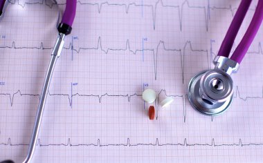 Stetoskop ve beyaz arka planda izole edilmiş bazı haplar.