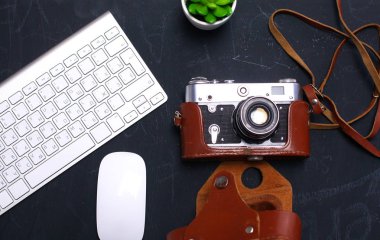 Masada üstten görünüm office grafik tasarım kalem fare ile laptop kablosuz fare ve vintage eski fotoğraf makinesi. Kavram grafik tasarım iş yeri