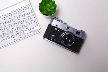 Beyaz masa üzerinde üstten görünüm office grafik tasarım kalem fare ile laptop kablosuz fare ve vintage eski fotoğraf makinesi. Kavram grafik tasarım iş yeri