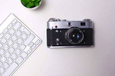 Beyaz masa üzerinde üstten görünüm office grafik tasarım kalem fare ile laptop kablosuz fare ve vintage eski fotoğraf makinesi. Kavram grafik tasarım iş yeri