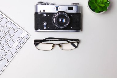Beyaz masa üzerinde üstten görünüm office grafik tasarım kalem fare ile laptop kablosuz fare ve vintage eski fotoğraf makinesi. Kavram grafik tasarım iş yeri