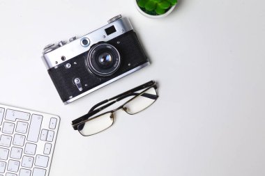 Beyaz masa üzerinde üstten görünüm office grafik tasarım kalem fare ile laptop kablosuz fare ve vintage eski fotoğraf makinesi. Kavram grafik tasarım iş yeri