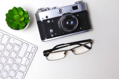 Beyaz masa üzerinde üstten görünüm office grafik tasarım kalem fare ile laptop kablosuz fare ve vintage eski fotoğraf makinesi. Kavram grafik tasarım iş yeri