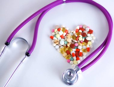 Stetoskop ve beyaz arka planda izole edilmiş bazı haplar.