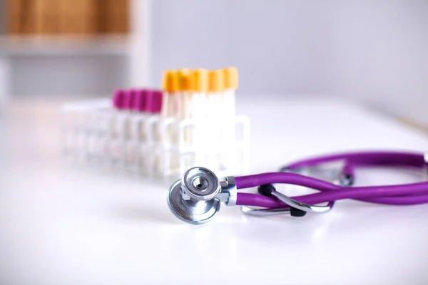 Stéthoscope près des tubes médicaux sur fond blanc — Photo