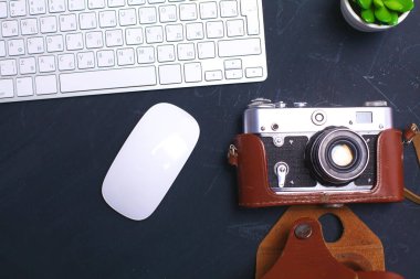 Masada üstten görünüm office grafik tasarım kalem fare ile laptop kablosuz fare ve vintage eski fotoğraf makinesi. Kavram grafik tasarım iş yeri