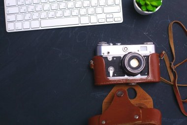 Masada üstten görünüm office grafik tasarım kalem fare ile laptop kablosuz fare ve vintage eski fotoğraf makinesi. Kavram grafik tasarım iş yeri