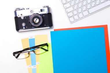 Beyaz masa üzerinde üstten görünüm office grafik tasarım kalem fare ile laptop kablosuz fare ve vintage eski fotoğraf makinesi. Kavram grafik tasarım iş yeri