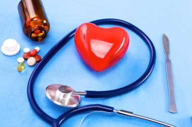 Stetoskop ile hapları ve tablo arka plan üzerinde kırmızı kalp