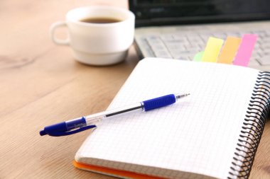 Bir not defteri, laptop, kalem, milimetrik kağıt belge beyaz kör arkasında ofis resepsiyon masası üzerinde